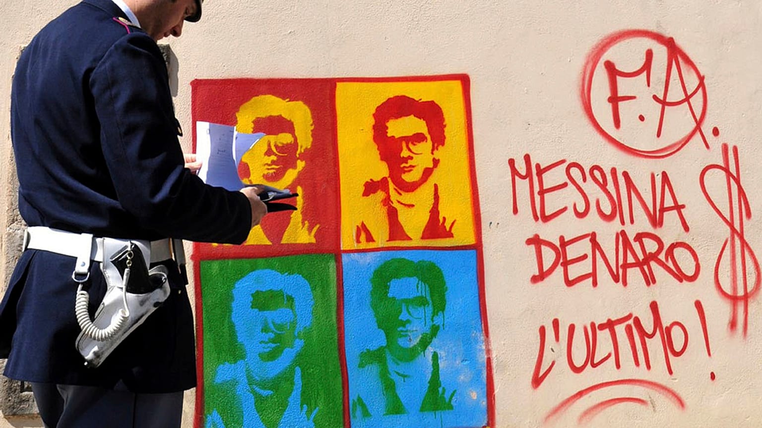 Um polícia em frente a um mural que representa o chefe Matteo Messina Denaro, 24 de abril de 2008, Palermo, Itália