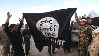 Bu arşiv fotoğrafta, Irak güvenlik güçleri ve müttefik Şii milisler IŞİD bayrağıyla beraber, 31 Mart 2015