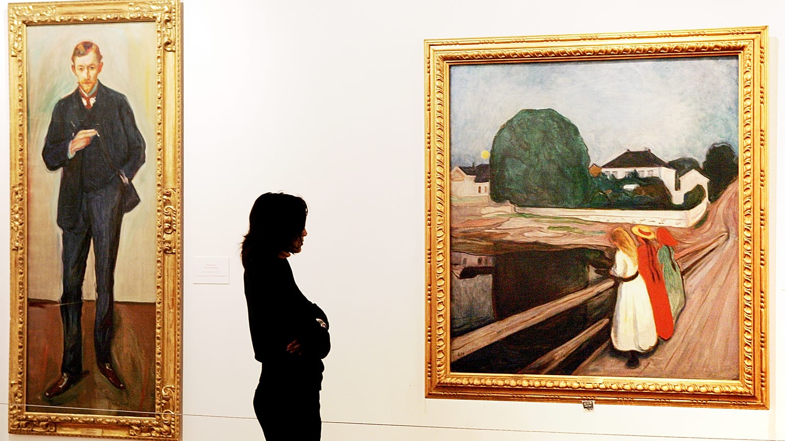 Imagen de una ciudadana viendo una exposición con cuadros del pintor noruego Edvard Munch.