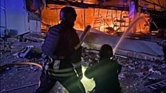 Ukrayna'nın itfaiye ekipleri Rus füzelerinin isabet ettiği bir binada çıkan alevleri söndürürken.