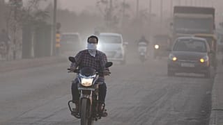 Imagen de un hombre con la cara cubierta mientras conduce su motocicleta, rodeado de aire contaminado en Ahmedabad, la India, el miércoles 5 de febrero de 2025.
