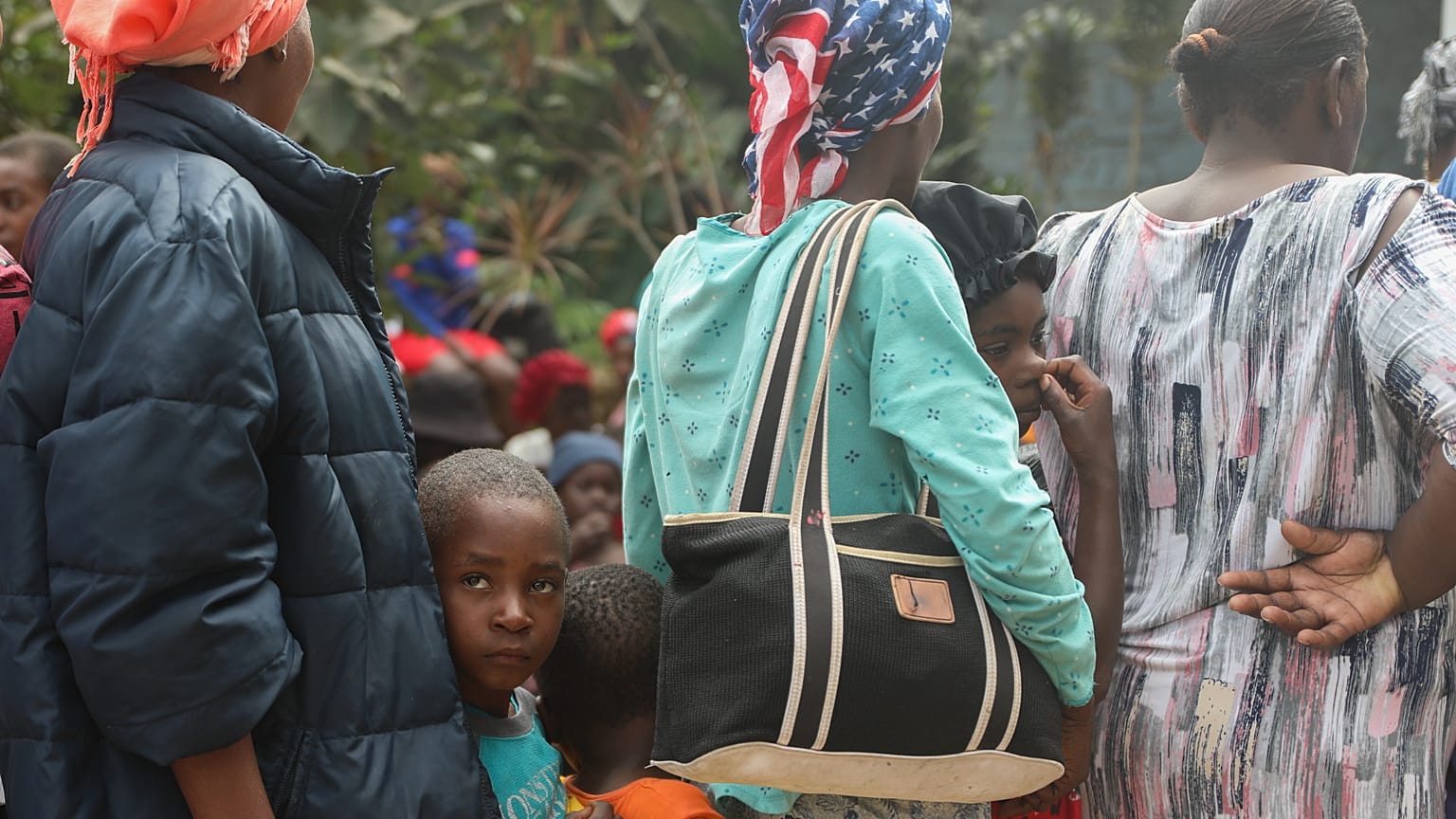 Pessoas fazem fila para receber comida num abrigo para famílias desalojadas pela violência de gangues no bairro de Kenscoff, em Port-au-Prince, Haiti.