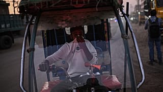 Un conductor se tapa la boca y la nariz ante la rampante contaminación de India.