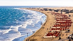 Turistas disfrutando del sol en la playa de Maspalomas en Gran Canaria