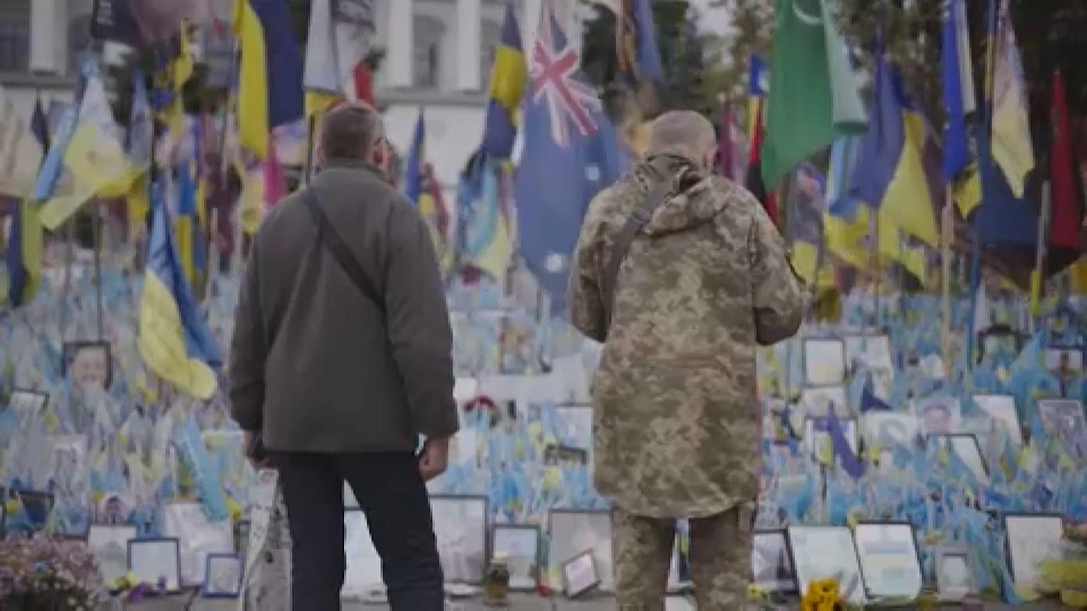 People stand in from of Maiden Square memorial in Kyiv, Ukraine, 2024. 