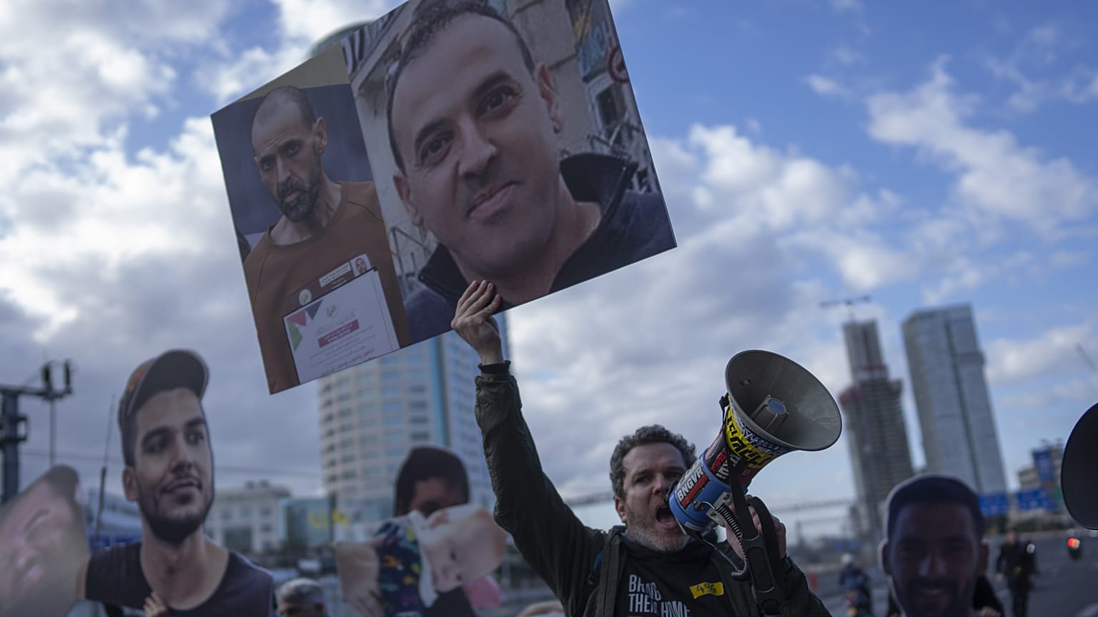 Un manifestante sostiene fotos del rehén israelí liberado Eli Sharabi antes y después de su cautiverio. 