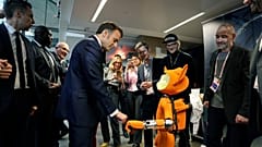 Prezydent Francji Emmanuel Macron, w środku po lewej, uderza pięścią robota podczas wizyty w Station F, w ramach wydarzenia na marginesie Artificial Intelligence Action.