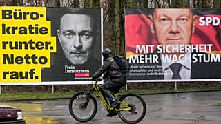 Um cartaz eleitoral dos Liberais Democratas (FDP) com o antigo Ministro das Finanças Christian Lindner ao lado de um cartaz dos Sociais Democratas (SPD) com a Chanceler alemã.