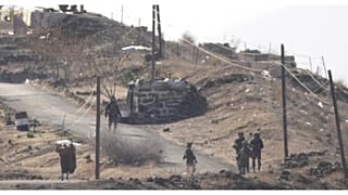 مواطن سوري يقف أمام مجموعة جنود إسرائيليين في نقطة جديدة تقدموا إليها وأقاموا موقعاً بها ف قرية المعرية بالجولان السوري، 19 ديسمبر 2024.
