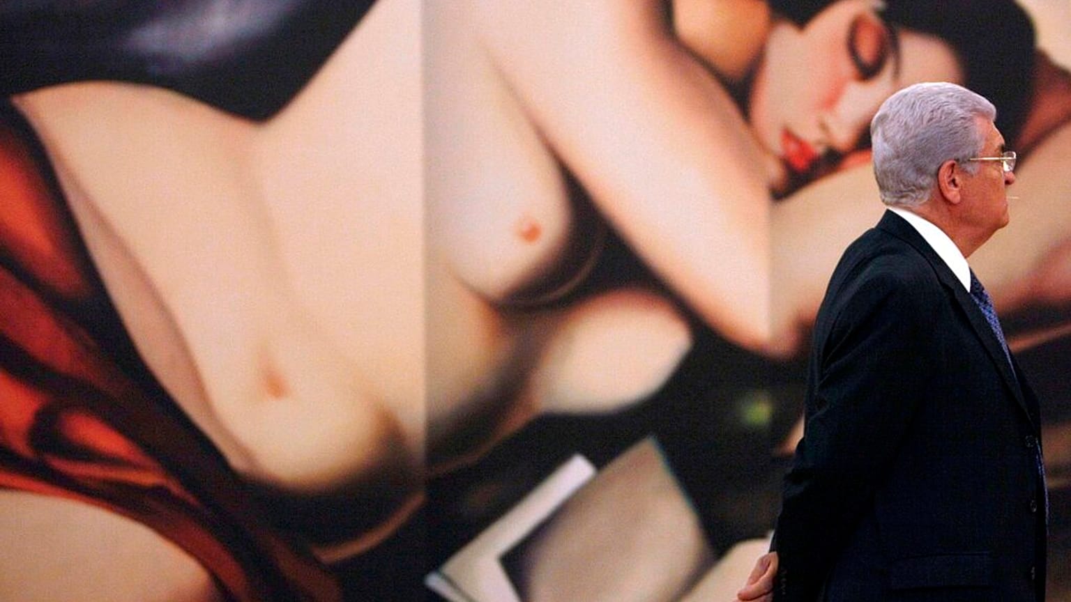 A man passes an image by Polish painter Tamara de Lempicka, during the inauguration of an exhibit of her life's work at the Bellas Artes Museum in Mexico City, Thursday, June 
