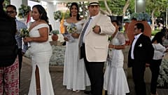 Groom Juan Carlos Torres, center, and bride Maylen Gonzales from Venezuela, wait in line to be married in a mass wedding organized by the municipality of Lima 