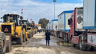 Excavadoras y camiones con convoyes esperan para entrar en Gaza en el paso fronterizo de Rafah entre Egipto y la Franja de Gaza, jueves 13 de febrero de 2025.