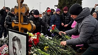 Varias personas depositan flores ante la tumba del líder opositor ruso Alexei Navalny, un año después de su muerte, en el cementerio de Borisovskoye, en Moscú, el domingo 16 de febrero de 2025.