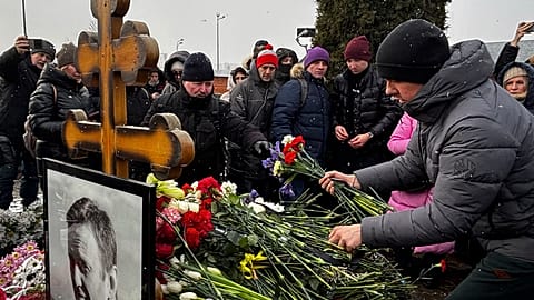 Люди возлагают цветы к могиле российского оппозиционера Алексея Навального через год после его смерти на Борисовском кладбище в Москве в воскресенье, 16 февраля 2025 года. 