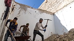 أشخاص يزيلون الأنقاض من داخل منزل تعرض للتدمير والنهب في معرة النعمان في ضواحي إدلب، سوريا، الأربعاء 15 يناير/كانون الثاني 2025