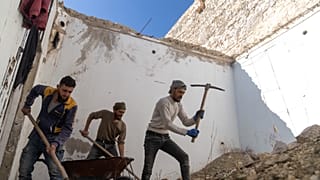 أشخاص يزيلون الأنقاض من داخل منزل تعرض للتدمير والنهب في معرة النعمان في ضواحي إدلب، سوريا، الأربعاء 15 يناير/كانون الثاني 2025