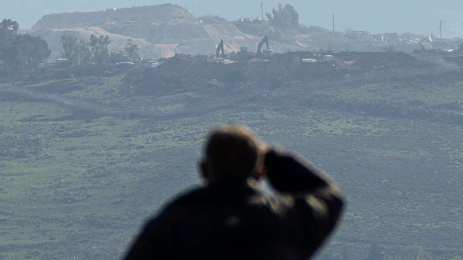 Un libanés observa las excavadoras mientras trabajan en la colina de Hamamis, cerca de la ciudad de Khiam, al sur del Líbano, el lunes 17 de febrero de 2025.