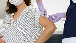 A pregnant woman receives a vaccination.