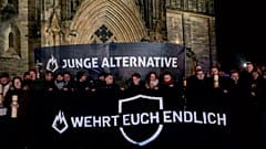 DOSYA: Magdeburg'daki katedralin önünde AfD'nin seçim kampanyasına katılan insanlar "genç alternatif, kendini savun" yazılı pankartlar taşıyor, 23 Aralık 2024