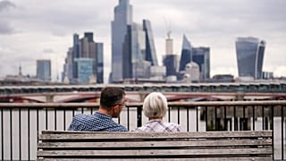 Two people sit on a bench in London in September 2023.