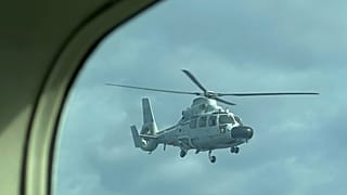 Un elicottero militare cinese vola vicino a un aereo dell'Ufficio filippino per la pesca e l'acquacoltura (BFAR) sopra Scarborough shoal il 18 febbraio 2025.
