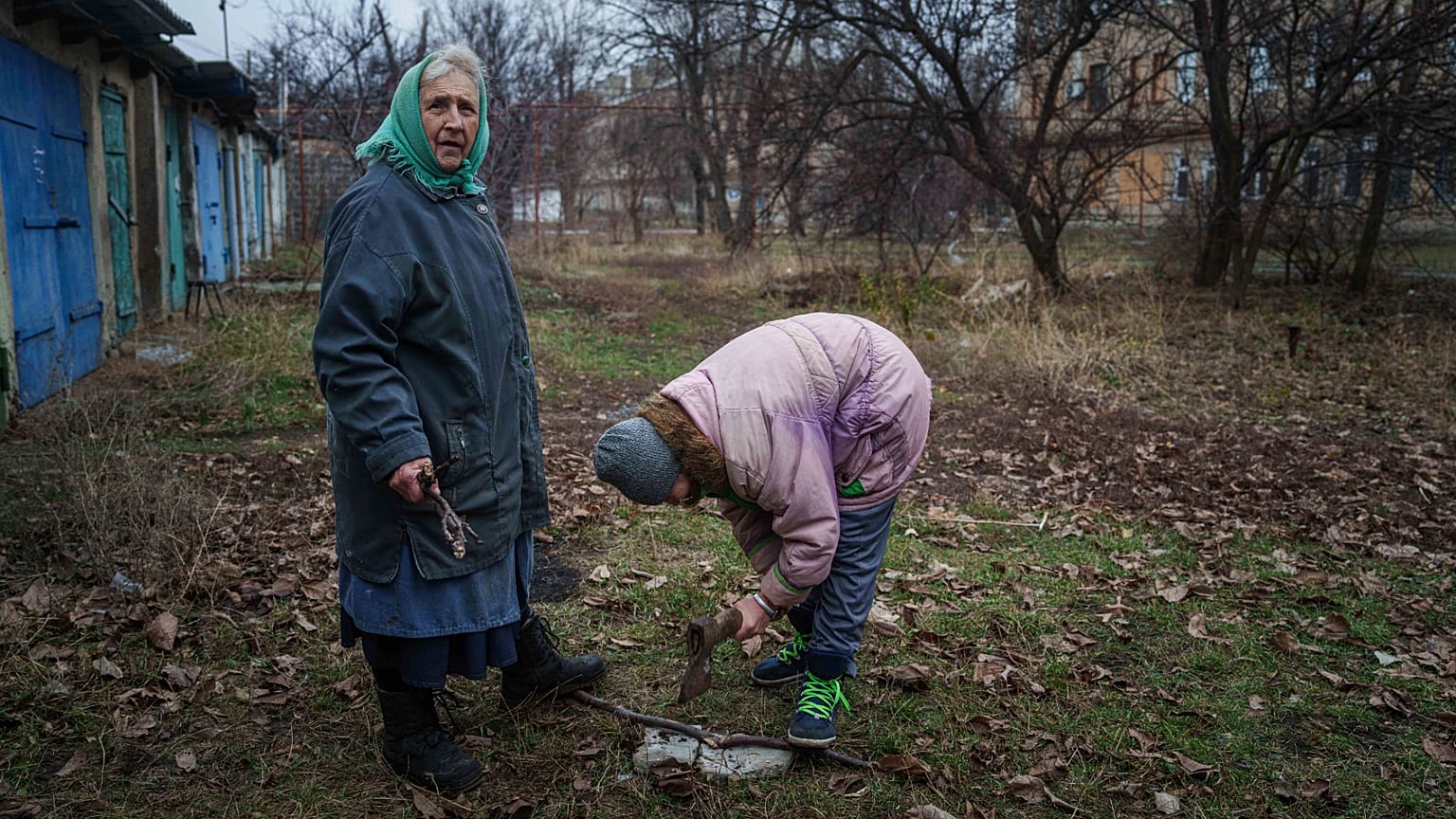 Mujeres locales cortan leña en el patio de su casa en Pokrovsk, Ucrania, el 21 de diciembre de 2024. 