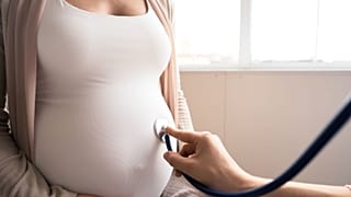 A pregnant woman receives an exam at a clinic.