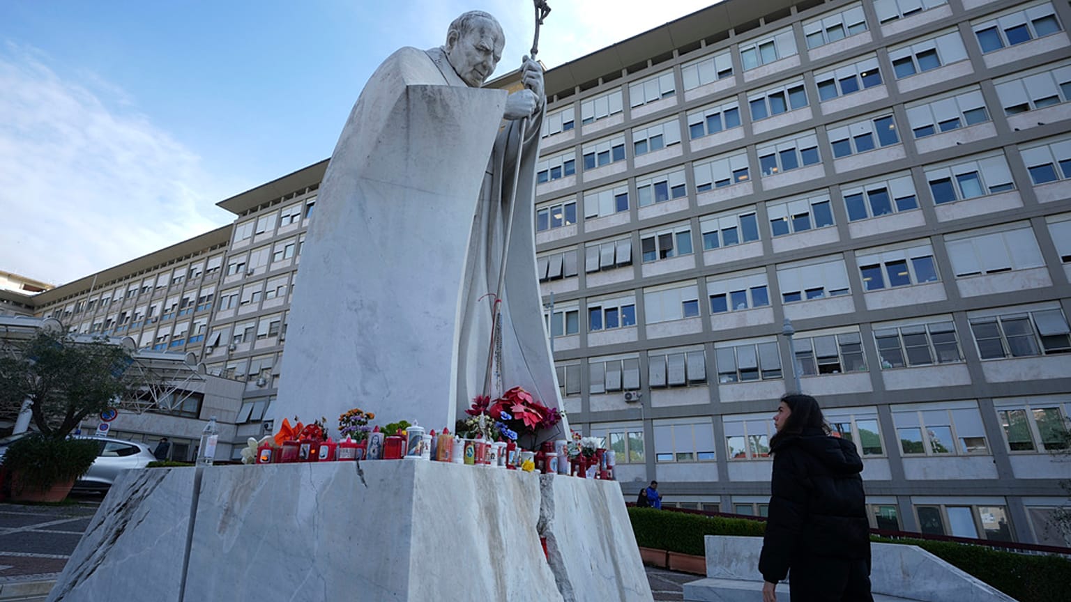 Una donna guarda la statua di Papa Giovanni Paolo II davanti al Policlinico Agostino Gemelli, a Roma, gìì20 febbraio 2025ì