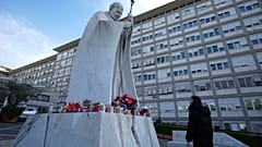 Una donna guarda la statua di Papa Giovanni Paolo II davanti al Policlinico Agostino Gemelli, a Roma, gìì20 febbraio 2025ì