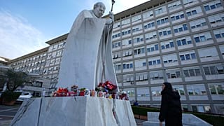 Una donna guarda la statua di Papa Giovanni Paolo II davanti al Policlinico Agostino Gemelli, a Roma, gìì20 febbraio 2025ì