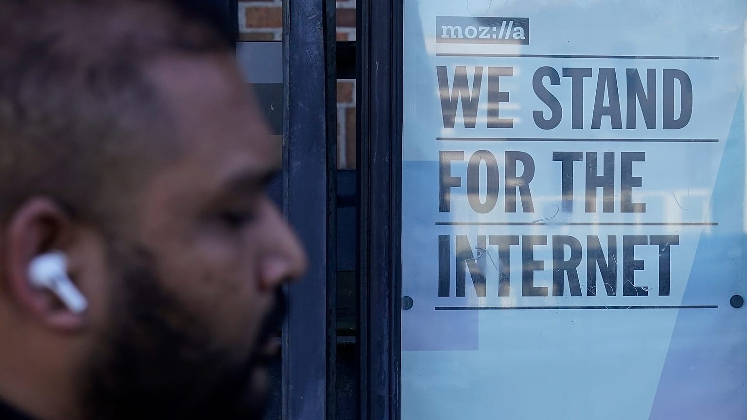Un piéton passe devant un panneau à l'extérieur des bureaux de Mozilla à San Francisco, le mercredi 12 avril 2023.