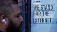 Un piéton passe devant un panneau à l'extérieur des bureaux de Mozilla à San Francisco, le mercredi 12 avril 2023.