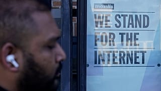 Un piéton passe devant un panneau à l'extérieur des bureaux de Mozilla à San Francisco, le mercredi 12 avril 2023.