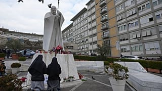   Schwestern beten für Papst Franziskus vor der Statue von Johannes Paul II. im Allgemeinen Krankenhaus Agostino Gemelli, Rom, Donnerstag, 20. Februar 2025
