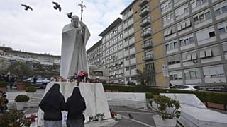 Nővérek imádkoznak Ferenc pápáért II. János Pál pápa szobra előtt