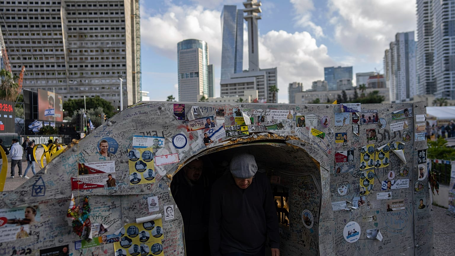 Un visiteur traverse une réplique d'un tunnel de la bande de Gaza, sur la place où se rassemblement les familles des otages à Tel Aviv, en Israël.