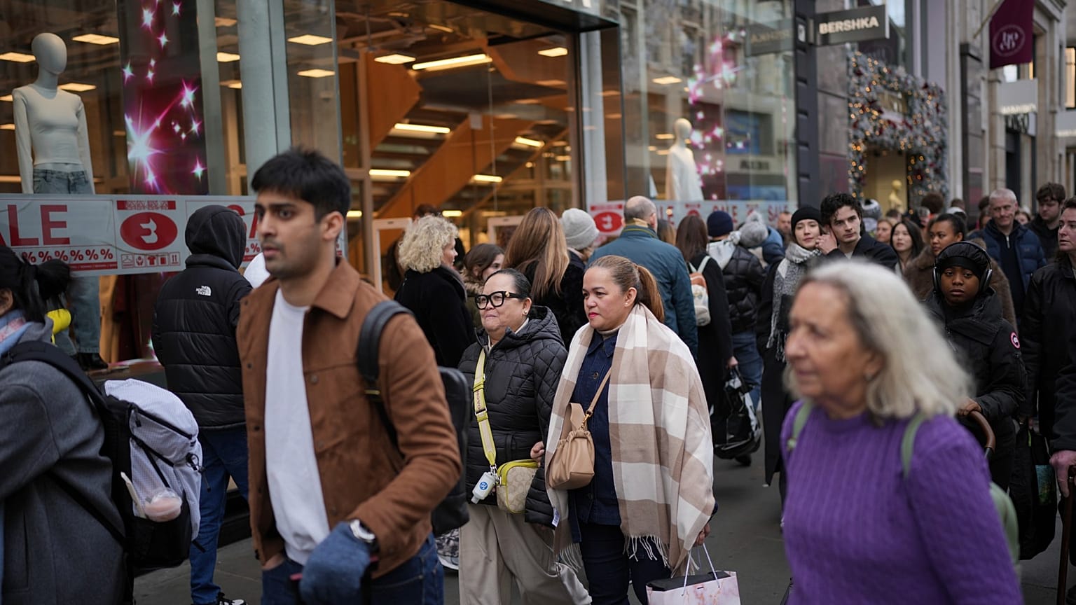 File photo of people passing a shop advertising for post-Christmas sales on Oxford Street in London, Monday, Dec. 30, 2024. 