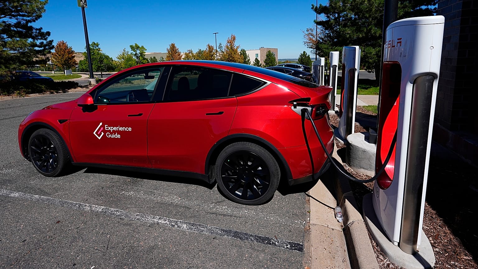  A Tesla Model 3 charges at a Tesla supercharging station in a parking lot in Lakewood, Colorado.