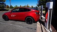  A Tesla Model 3 charges at a Tesla supercharging station in a parking lot in Lakewood, Colorado.