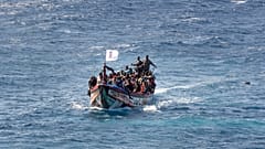  مهاجرون على متن قارب خشبي أثناء إبحارهم نحو ميناء لا ريستينجا في جزيرة إل هييرو بجزر الكناري، إسبانيا، يوم الأحد 18 أغسطس 2024.