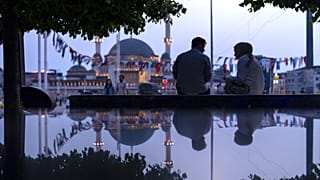 Bir çift, 22 Mayıs 2024 Çarşamba günü İstanbul'daki Taksim Meydanı'nda bir bankta otururken görüntüleniyor.
