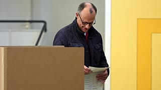 Friedrich Merz, leader de CDU, se dirige vers un isoloir avec son bulletin de vote dans un bureau de vote à Arnsberg-Niedereimer, le 23 février 2025.