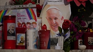 Papa Francis'in bir resmi Roma'daki Gemelli Hastanesi önünde mumlar arasında görülüyor, 23 Şubat, 2025
