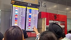 People at the New Delhi international airport read an electronic display showing an American Airlines flight from New York was diverted to Rome, 23 February 2025