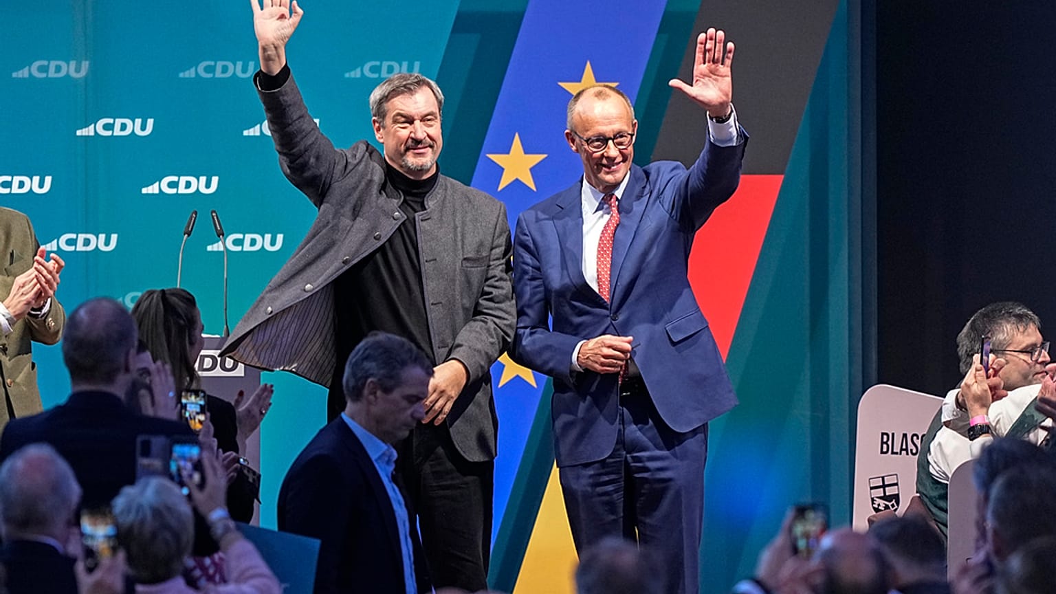 Friedrich Merz de l'Union chrétienne-démocrate (CDU) et le gouverneur de Bavière Markus Soeder saluent leurs partisans à Brilon, en Allemagne, le 19 janvier 2025.