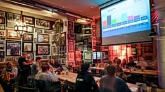 Menschen beobachten die ersten Hochrechnungen in einer Kneipe in Berlin, Sonntag, 23. Februar 2025, nach der Bundestagswahl. 