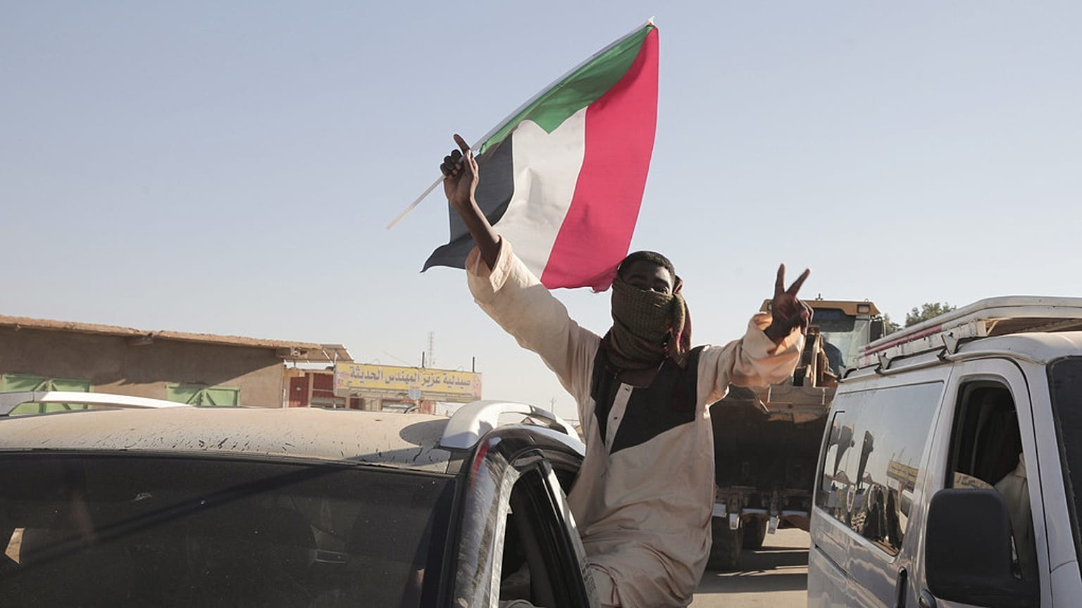 ملف: رجل سوداني يلوح بعلم السودان في مروي، السودان، السبت، 11 يناير/كانون الثاني 2025.