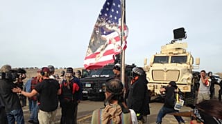 Dakota Access pipeline protesters defy law enforcement officers who are trying to force them from a camp on private land in the path of pipeline construction on 27 Oct 2016.