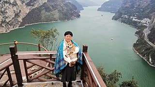 Una turista posa junto a una montaña de Yichang (China) que parece un cachorro