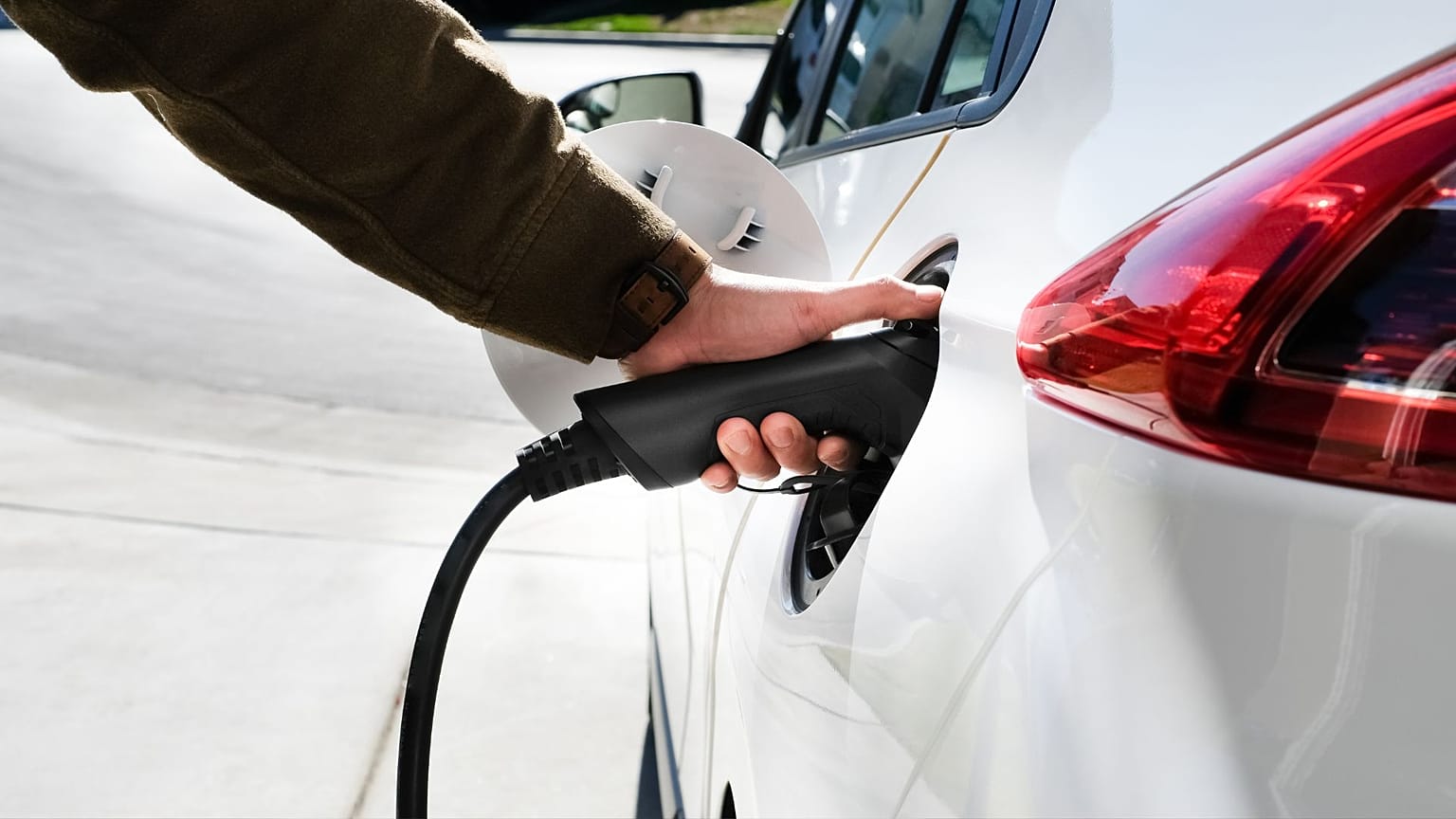 Elektrikli arabasını şarj eden bir kişi
